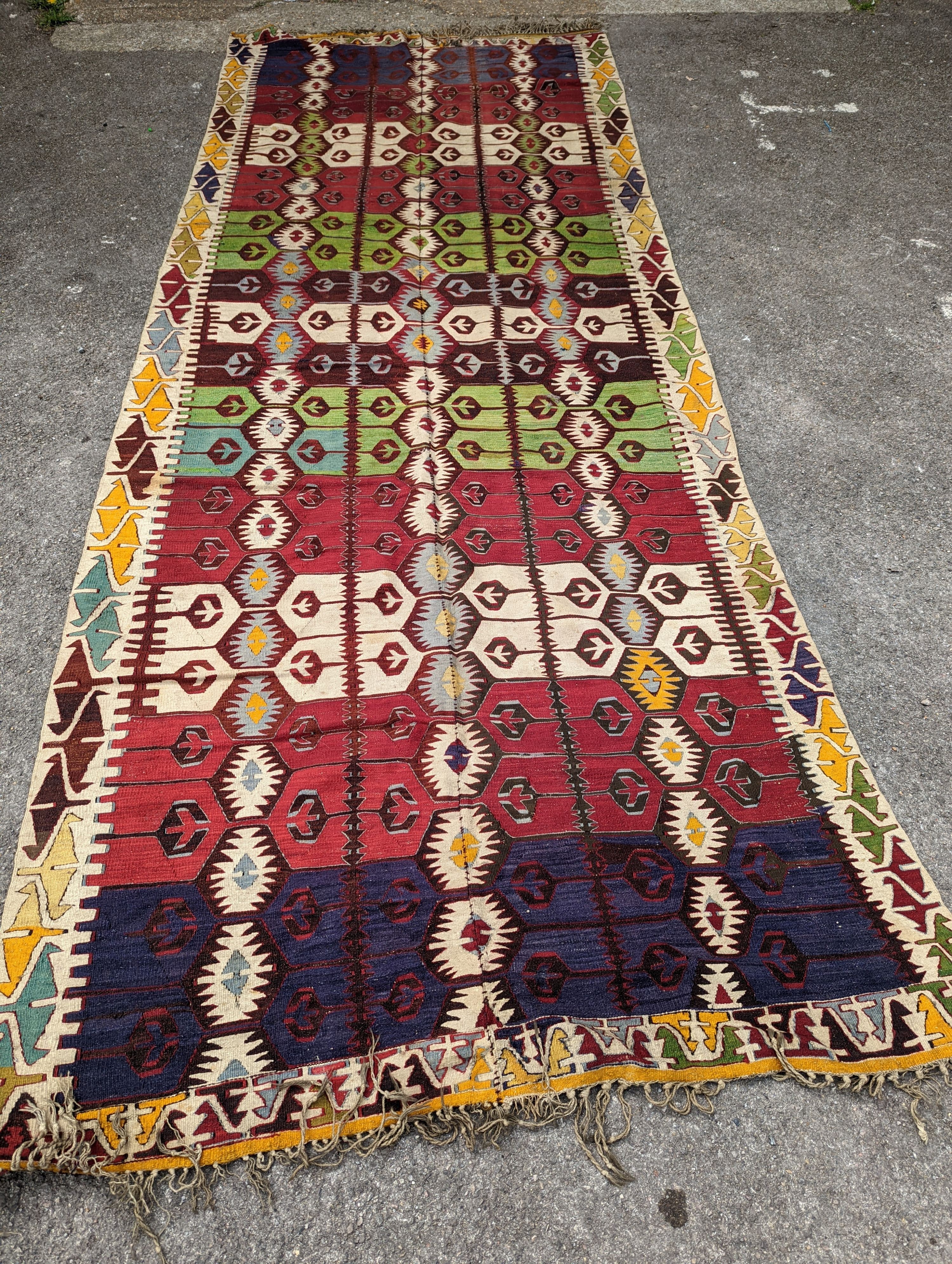 A Kelim polychrome flatweave carpet , cut centrally and re stitched, 425 x 163cm